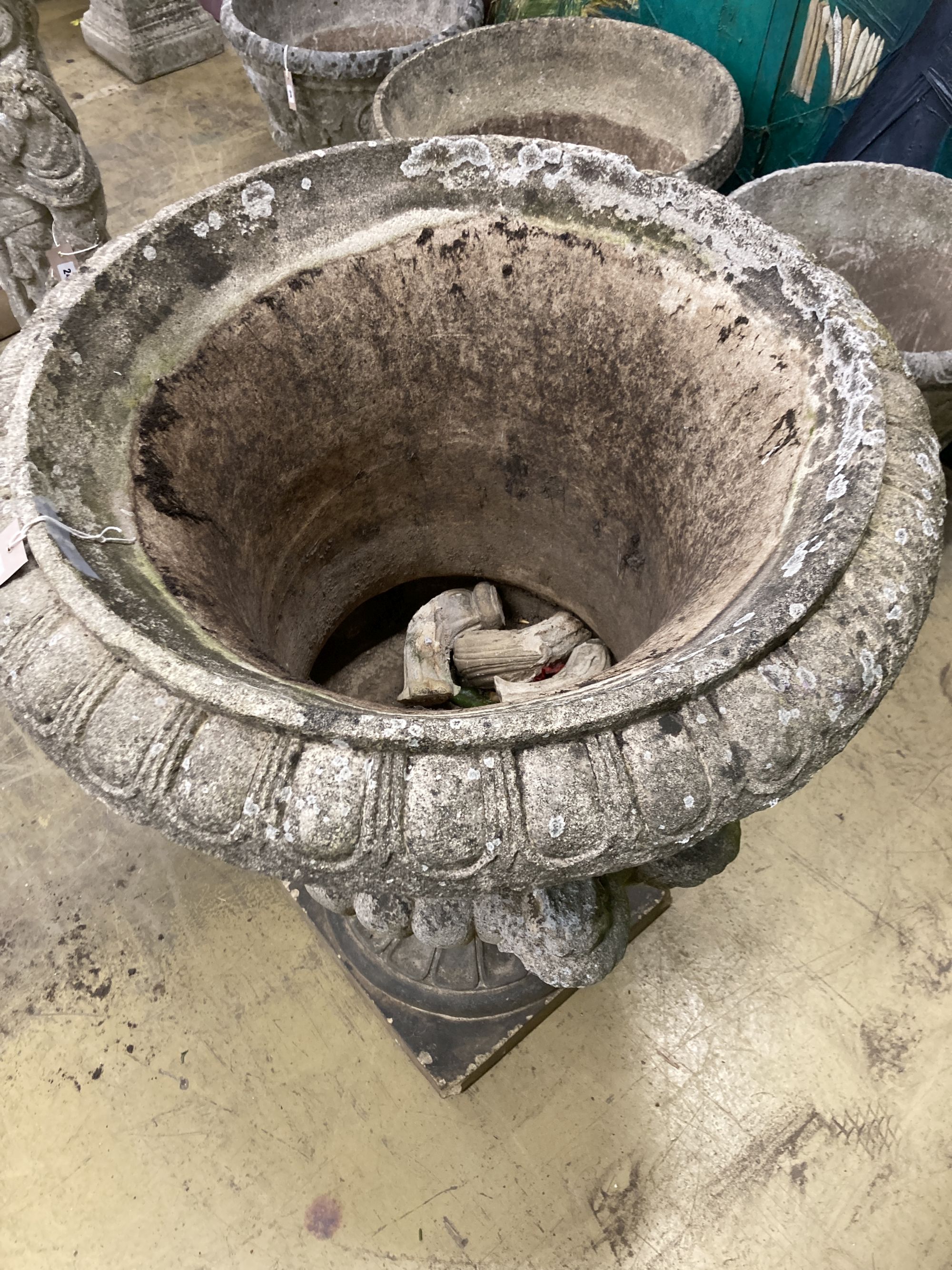 A large reconstituted stone campana garden urn, handles in need of repair, 75cm diameter, height 96cm